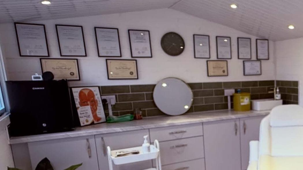 Rachel's certificates framed on the wall of her treatment room, above the counter